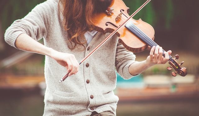 girl in cardigan playing violin