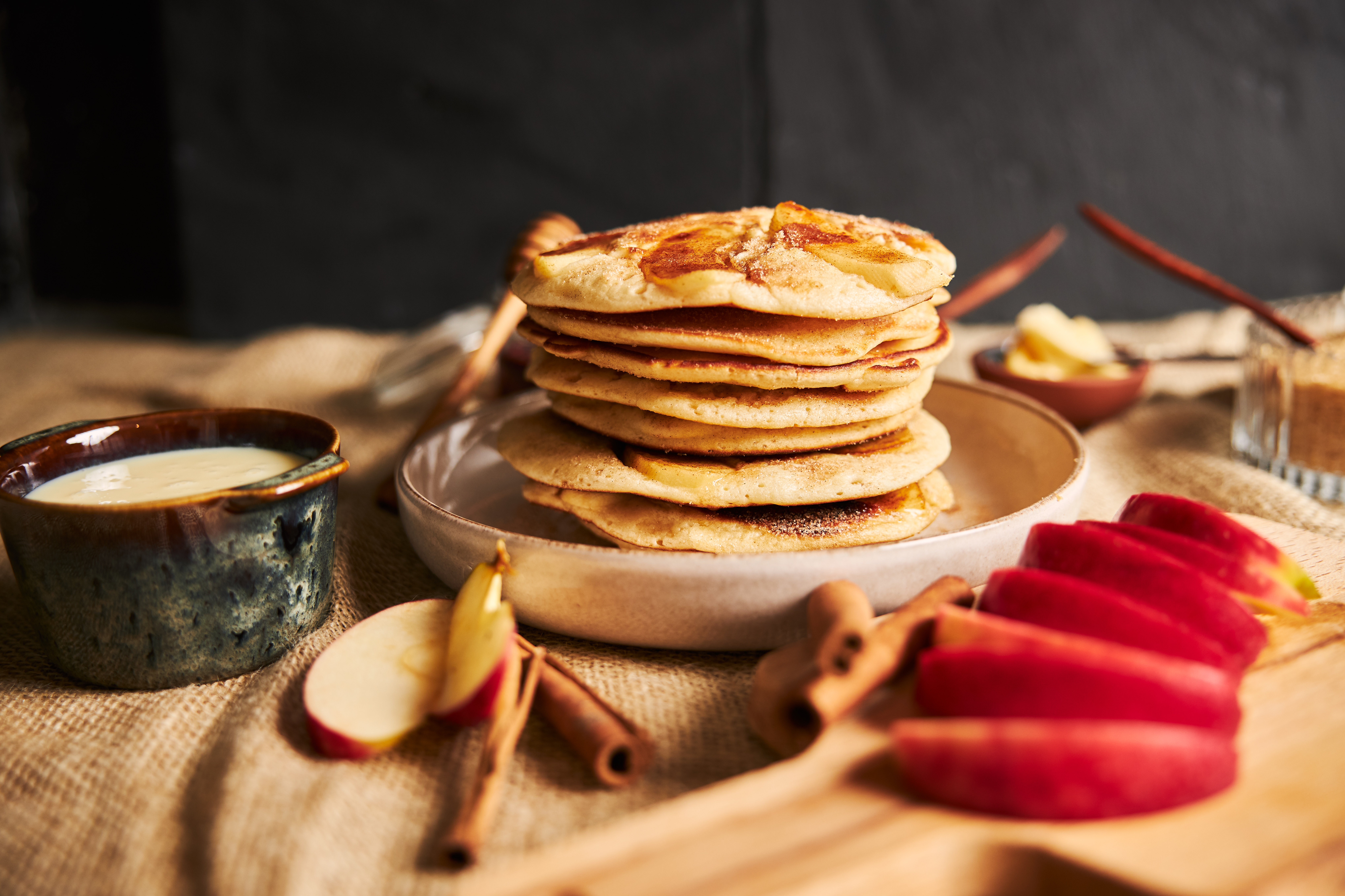 Pancakes with apple slices and cinnamon on table for pancake day 